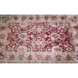 A large Afghan Chubi carpet, with stylized floral design on a rouge and beige ground, bought from