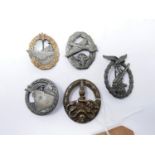 A collection of five reproduction Third Reich badges, to include Naval, Artillary and Luftwaffe