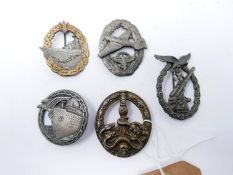 A collection of five reproduction Third Reich badges, to include Naval, Artillary and Luftwaffe