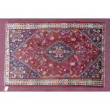 A South West Persian Qashqai rug, central diamond medallion with repeating petal motifs on a