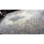 A large 20th century woolen carpet, with central floral medallion on a cream ground, contained by