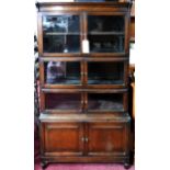 An early 20th century 'Minty' oak four section bookcase, with makers label, H.162 W.89 D.32cm