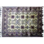 An Afghan rug with repeating floral geometric motifs, on a light brown ground, contained by