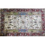 A large Afghan carpet with vase and flower motifs design, on a beige ground, contained by floral