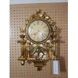 A gilt wall clock in the Neo Classical taste, the round convex dial with Arabic numerals, the case