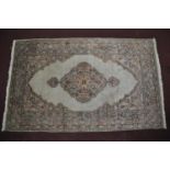 A 20th century part silk Hereke rug, with floral medallion on a cream ground, contained by floral