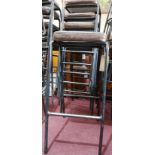 A set of 6 industrial black steel bar stools with brown leather seats