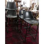 A set of 4 industrial bar stools with leather clad tub seats
