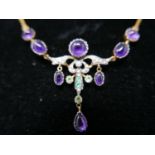 A boxed yellow gold drop necklace set with amethyst cabochons, seed pearls, emerald and peridot,