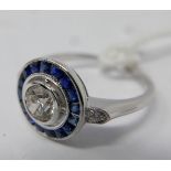 An 18ct white gold sapphire and diamond ring, centrally set with a round brilliant-cut diamond to an