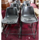 A set of 6 industrial bar stools with leather clad tub seats