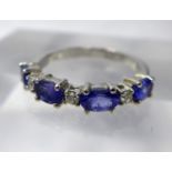 A 14ct white gold, diamond and tanzanite ring, alternately set with three round briliant-cut