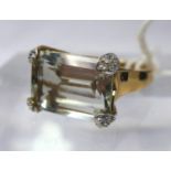 A 9ct yellow gold, diamond and green amethyst ring, centrally set with a large, stepped-cut icy