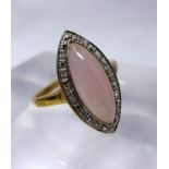 A 9ct yellow gold diamond and rose quartz ring, centrally set with a marquise-shaped rose quartz