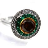 An Art Deco style 18ct white gold emerald and diamond target style ring, centrally set with a round,
