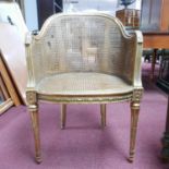 A late 19th/early 20th century French gilt wood and cane chair, the double caned back rest in need