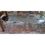 A contemporary chrome coffee table of unusual form, on three legs, H.45 W.177 D.88cm