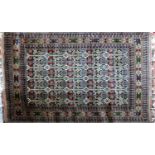 An Afghan rug with repeating geometric motifs, on a beige ground, contained by geometric borders,