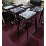 A set of 6 industrial black steel bar stools with brown leather seats