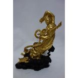 A carved gilt painted figure of Guanyin, standing on a stylised cloud base with gilt rabbit, H.33cm