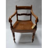 A 19th century teak scroll arm desk chair