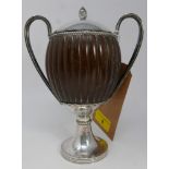 An early 20th century silver twin handled coconut cup, London 1914, the lid with acorn finial, on