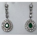 A boxed pair of 18ct white gold emerald and diamond cluster drop earrings, each earring suspended by
