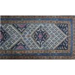 An antique Persian runner with triple diamond medallion on a beige ground surrounded by geometric