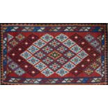 A South West Persian Qashqai kilim, repeating stylised geometric motifs on a rouge field within