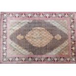 A 20th century part silk Tabriz rug with diamond medallion surrounded by floral motifs, contained by