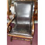 A mahogany scroll armchair with studded leather upholstery