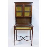 An Edwardian mahogany and boxwood inlaid display cabinet, with two glazed doors over hinged