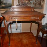 An early 20th century oak writing table, single drawer, raised on cabriole legs, H.96 W.81 D.51cm