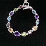A sterling silver and muti-gem set necklace set with faceted amethysts, peridot, garnet, citrine and