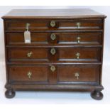 An early 18th century oak chest of four graduating drawers, with original brass handles and