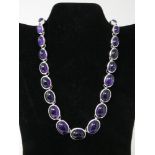 A sterling silver and graduated amethyst cabochon necklace composed of 21 polished amethysts, L: