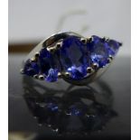 A boxed 14ct white gold tanzanite and diamond ring, set with five graduated oval faceted natural