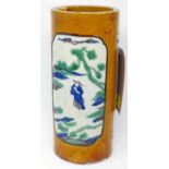 A late 19th century Chinese cylindrical brush pot holder depicting 2 panels of figures within