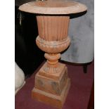 Two cast iron urns, raised on stepped square plinths, H.101cm Diameter 54cm