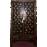 An early 20th century Chinese black and red lacquered wedding cabinet, decorated with butterflies,