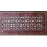A North East Persian Turkoman rug, repeating Tekkeh motifs on an ivory field within stylised