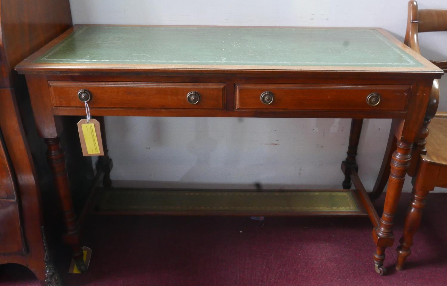 An Edwardian mahogany writing table, two drawers, green leather skiver, raised on turned legs and