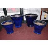 Four blue glazed planters, of fluted and tapered form, comprising two medium, H.45cm Diameter