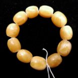 A yellow amber beaded bracelet composed of 11 large ovoid beads, bracelet dia: 8cm, 35g.