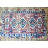 A 20th century Caucasian carpet with three geometric medallions, surrounded by animal and