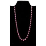 An early 20th century sterling silver and faceted pink crystal necklace set with 38 oval, faceted