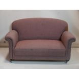 An early 20th century drop end sofa raised on bun feet and castors