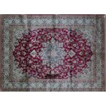 A Kashan style carpet with central floral medallion, on a red ground, contained by floral borders,