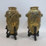 A pair of late 19th/early 20th century Chinese heavy brass vases, decorated with dragons and bearing