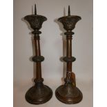 Two large brass pricket candlesticks, with scrolling foliate decoration, on spreading foot (2)
